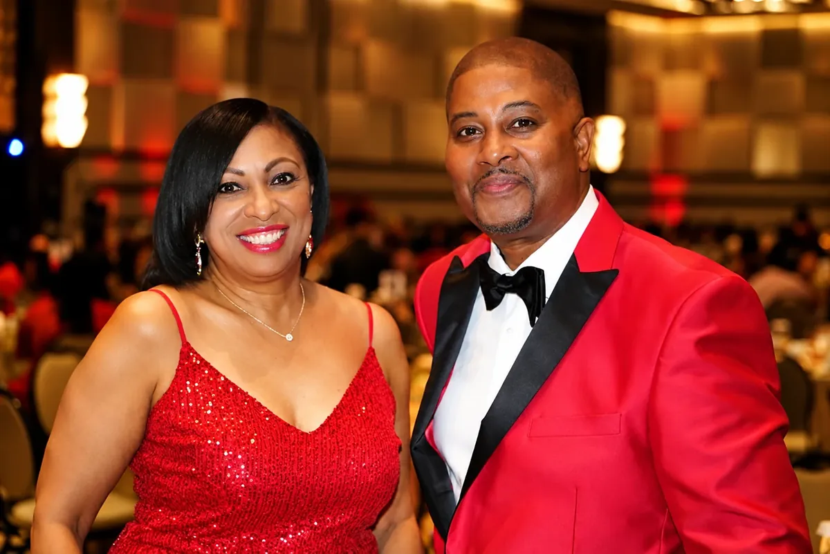 Couple in coordinated red formal attire posing at an evening event